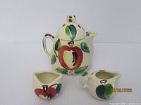 Front view of all three pieces showing matching Open Apple decoration