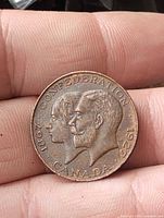 Obverse side showing dual portrait and dates 1867-1927