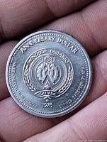 Obverse showing ANNIVERSARY DOLLAR legend, Windsor crest, 1976 date, redemption text