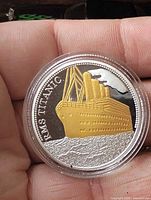 Obverse side showing gold plated RMS Titanic image and text