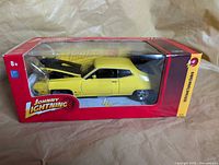 Front and side view of boxed yellow 1:24 scale 1970 Ford Torino Cobra model