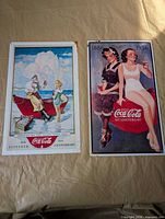Fronts of both Coca-Cola tin signs showing graphics and text