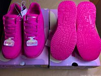 Top view of both pairs showing uppers, laces, tags, and boxes