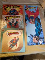 Four items laid out: three Superman LPs and one tall cardboard display