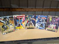Front view of five Gundam model kit boxes