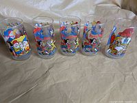 Five Disney promotional glasses in a row