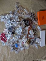 Overview of all bagged costume jewelry items and orange box