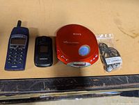 Group shot of Sony Walkman, Ericsson phone, Samsung phone, sealed earphones