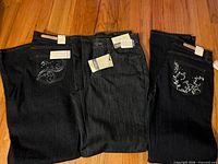 Three pairs of TL Jeans dark-wash denim laid out showing overall appearance and tags