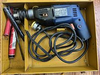 Drill, cord, bits, and accessories inside yellow case