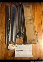 Boxed drying rack components: metal poles, connectors, clothespins, instruction sheet, outer box