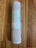 Rolled bath mat with label