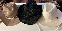 Front view of all three hats: tan, black, white
