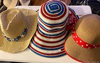 Three straw summer hats displayed on table