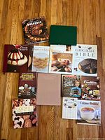 All 13 dessert cookbooks laid out on wood floor