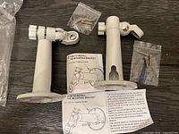Both camera brackets with screws and instructions visible