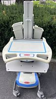 Front view showing work surface, keyboard tray, side bins, base with casters