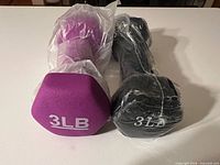 Purple and black 3 lb dumbbells, hex ends visible