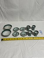 Group shot of all ten porcelain pieces with measuring tape for scale