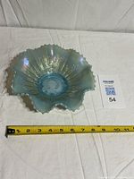 Top view of entire ruffled bowl with measuring tape showing approx 9 in diameter