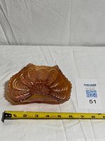 Top view showing full peacock tail pattern and scalloped edges with tape measure for scale