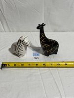 Zebra and giraffe shakers beside measuring tape showing size