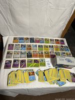 Overview of entire lot: rows of holo cards, piles of bulk cards, Cosmic Eclipse Energy box