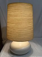 Lamp assembled, lit, showing shade texture and base