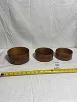 All three teak bowls side by side with tape for scale