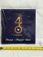 Front view of sealed book showing 40 Years Prince + Purple Rain cover design and scale