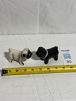 Top view of both ceramic pug shakers with tape measure indicating size