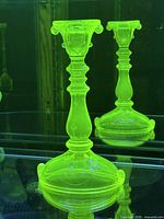Candlestick glowing green under UV light showing fluorescence and decorative details