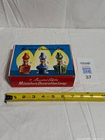 Box lid showing product illustration and measuring tape for scale