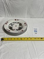 Stack of four plates with tape measure showing diameter