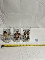 All three WWF wrestler glasses with measuring tape for scale