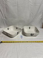 Both square skull-pattern bowls side by side with tape measure showing 8-inch width