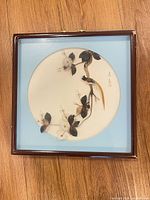 Front view of framed feather art piece