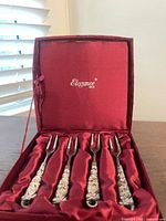 Open presentation box showing four silver-plated forks