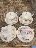 Four cup-saucer sets arranged on countertop
