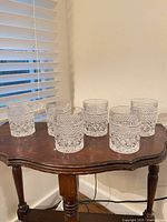 six tumblers on small wooden table