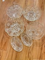 All six pressed glass pieces laid out, showing shapes and patterns