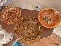 Group shot of three amber/marigold glass pieces on table
