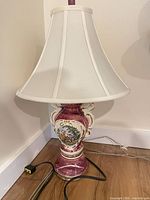 Full view of porcelain burgundy lamp with shade