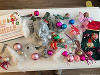 Overall lot showing Elf on the Shelf set, baubles, miniature trees, stocking and other ornaments on table