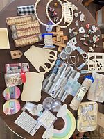 Table view of entire craft lot showing wood blanks, beads, ribbons, tools and adhesives
