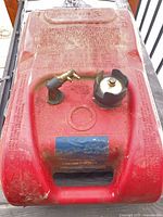 Top view of red Attwood 6-gallon fuel tank showing cap, connector, handle
