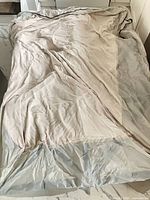 Canopy fabric spread out, showing beige upper surface and grey underside