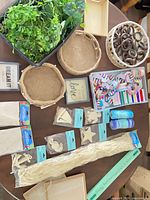 Overhead view showing faux greenery, jute baskets, tray, curtain rings basket, wood shapes, ribbon, raffia, framed signs