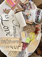 Table view of entire assortment: wood plaques, vinyl decals, stencils, stickers, pots, clothespins