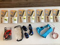 Full lot overview showing six Knot Out combs, Flexi leash box, clear vinyl bag, four dog boots, blue harness, pink collar